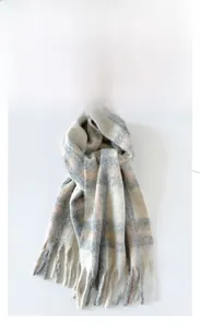 Close-up of fluffy thick mohair plaid scarf with long tassels in grey and pink