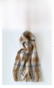 Close-up of thick beige and blue plaid mohair scarf with soft fringe tassel detail