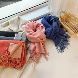 Détail d'écharpes colorées aspect cachemire avec des franges douces et tons vifs
