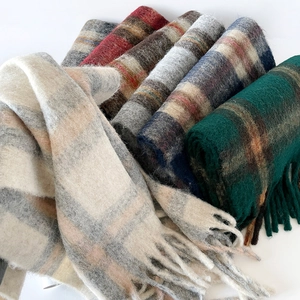 Close-up of thick multi-color plaid scarves with soft fringe and wool texture