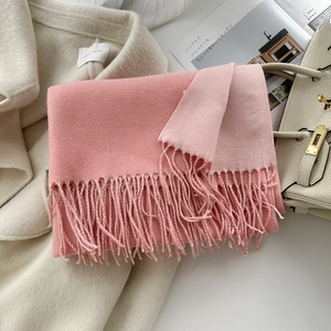 Détail d'une écharpe rose aspect cachemire montrant la texture douce et les franges