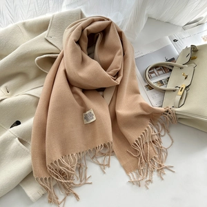 Détail de l'écharpe en cachemire camel et beige avec de longues franges et étiquette