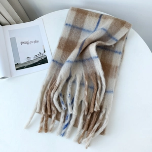 Detail view of thick mohair scarf with check pattern and fringes on white background