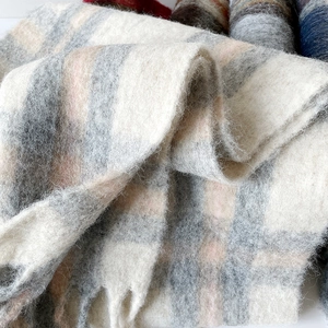 Close-up of thick plaid wool scarf showing soft mohair texture and elegant fringe details