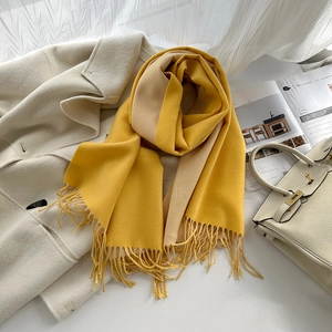 Texture détaillée de l'écharpe en cachemire réversible jaune et beige avec franges