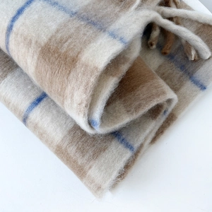 Close-up of thick plaid mohair scarf texture featuring cream and brown check patterns