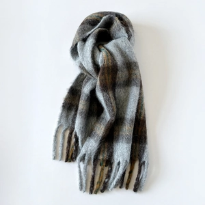 Detailed view of plaid wool scarf featuring soft mohair texture and long tassels