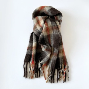 Close-up of thick plaid wool scarf with soft brushed texture and decorative long tassels