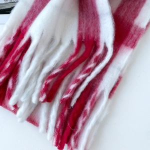 Close-up of fluffy red and white striped mohair scarf with twisted fringe details