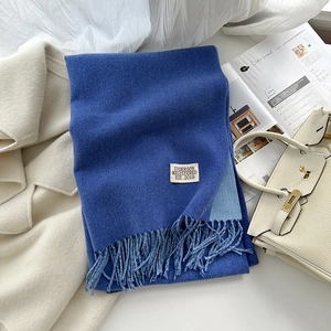 Détail de la texture du foulard en cachemire bleu roi avec franges et étiquette tissée