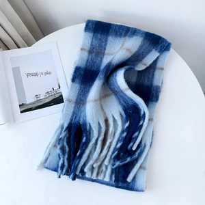 Detail of blue plaid mohair scarf with thick twisted tassels on white background