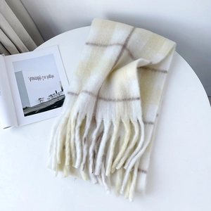 Close-up of thick beige and cream plaid mohair scarf with soft long fringe details