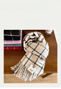 Detail shot of soft plaid scarves with fringe edges and brand labels on wooden background