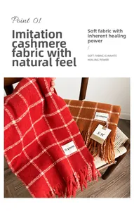 Detailed close-up of plaid cashmere feel scarf with fringe tassels on a wooden chair