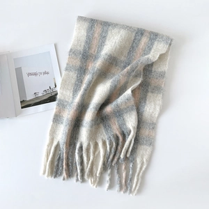 Detailed view of soft plaid wool scarf with fringes in cream, grey and pink tones