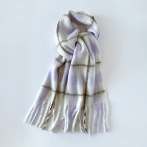 Detailed macro shot of light purple plaid mohair scarf with soft fringe edges for winter