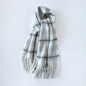 Macro view of white and grey plaid mohair scarf with soft texture and classic tassels