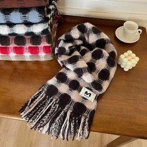 Detailed view of classic checkered scarf texture with fringe on a wooden table