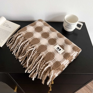 Close-up of brown vintage plaid cashmere scarf featuring detailed tassels and woven label