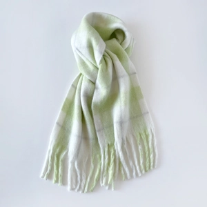 Detail of light green plaid mohair scarf with soft texture and fringed tassel edges