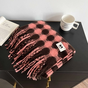 Detail of pink and brown checkered scarf with fringe and a sewn-on brand label