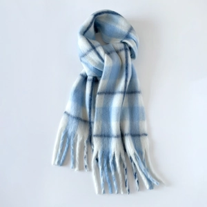Detailed view of the soft mohair texture and long tassels on the blue plaid scarf