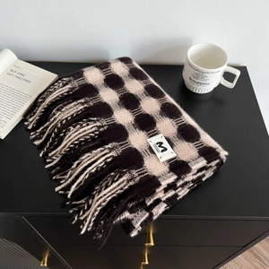 Close-up of black and white plaid cashmere scarf with tassel fringe and brand label