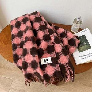Pink and brown plaid cashmere scarf with fringes on a rustic wooden background