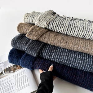 Close-up of assorted thick knit scarves with horizontal stripes and soft wool texture