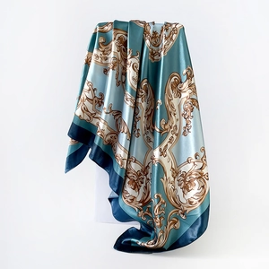 Detailed view of the blue silk satin scarf with elegant golden baroque pattern