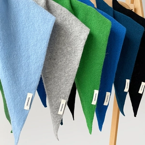 Detail of multi-color 100% wool knitted triangle scarves with composition labels