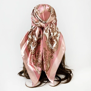 Detail view showing the elegant baroque pattern on a pink satin silk headscarf from behind
