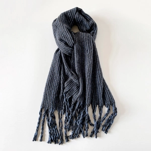 Macro shot of vertical grey and blue stripes with soft fringe on a thick knit scarf