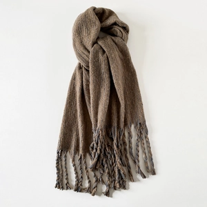 Detailed close-up of dark khaki wool scarf featuring hand-woven tassel fringe accents