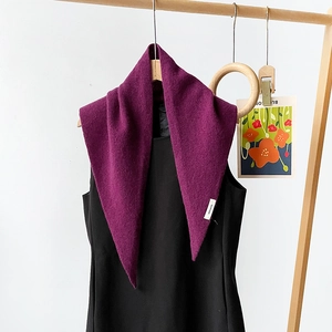 Detail of 100% wool knit triangle scarf in deep purple with material composition label