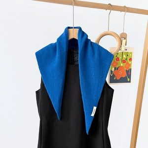 Detail view of the 100% pure wool triangular scarf with authentic material label