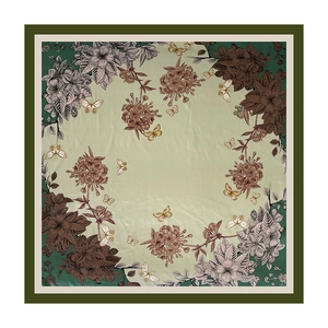 Dettaglio di farfalle vintage e motivi floreali su un foulard quadrato di seta verde