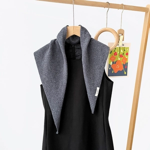 Close-up detail of the dark gray knitted wool triangle scarf with fine texture