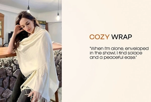 Detail of soft beige cashmere-like shawl featuring elegant long fringe and draped texture