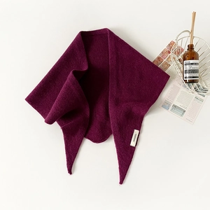 Close-up of 100% pure wool triangular scarf with premium knitted texture and brand tag