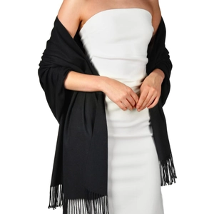 Solid black cashmere-feel scarf with fringes styled over a white evening dress