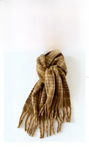 Close-up of thick tassels and fluffy mohair-style plaid scarf in brown and beige