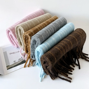 Close-up of soft plaid wool scarves with long fringe detail and colorful stripe patterns
