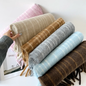 Macro detail of assorted wool plaid scarves showing soft mohair texture and long fringes