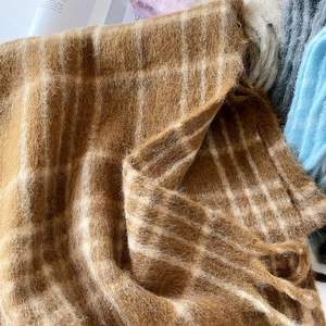 Close-up of brown and white plaid mohair scarf showing soft long-fiber wool texture