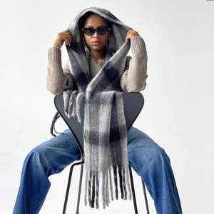 Close-up of black and grey plaid mohair scarf texture with long fringe tassels