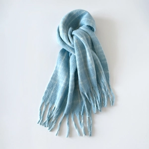 Close-up of soft blue and white plaid wool blend scarf with decorative fringe tassels