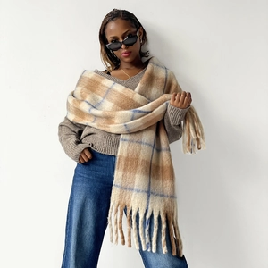 Close-up of thick plaid mohair scarf with blue accents and long fringe tassels