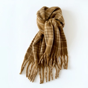 Detail of soft brown plaid wool blend scarf showing brushed texture and long tassels