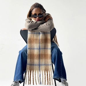 Close-up of thick checkered mohair scarf with blue stripes and long fringe details